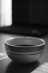 big stripped round bowl with black tea drink, bw photo.