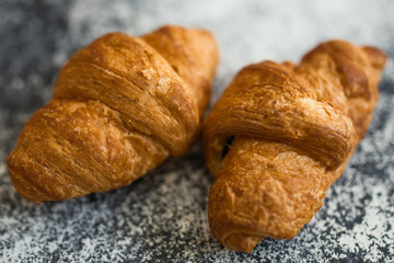 Macro closeup display of plain butter croissant crescent pastries in bakery for breakfast.