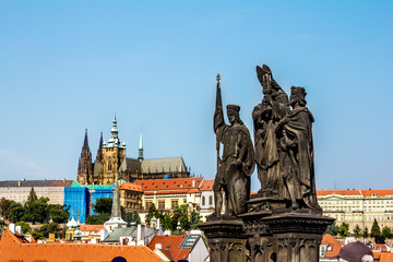 Fototapeta na wymiar Sculpture of Saints Norbert, Sigismund and Wenceslas on the Charles bridge on the background of Prague castle.