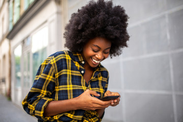  young black woman walking on street looking at cellphone