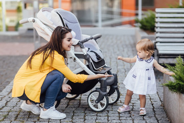 Portrait of happy older sister walking with small sister and playing together.