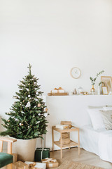 Scandinavian interior design apartments decorated in Christmas / New Year style with toys, gifts, fir tree. Festive winter holidays composition.