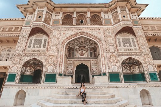 Woman sitting beside building