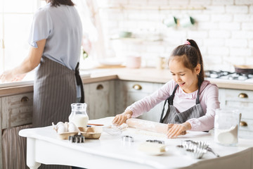 Little girl learning how to use rolling pin