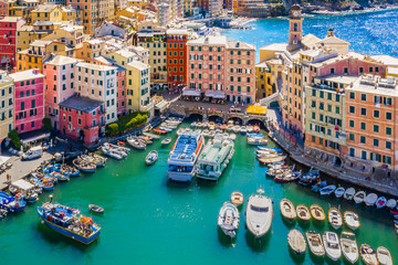 Fototapeta na wymiar Aerial view of Camogli. Colorful buildings near the ligurian sea beach. View from above on boats and yachts moored in marina with green blue water.