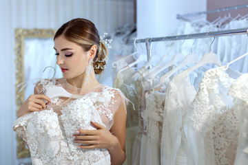 Young woman measures wedding dresses.