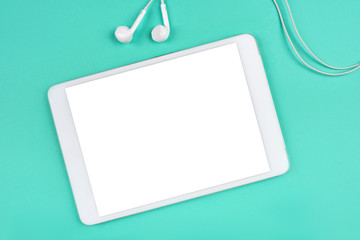 White digital tablet on mint background.