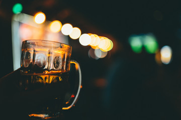 Beer in glass with bar lights behind