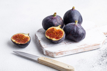 figs on white wooden Board knife half figs on a white background