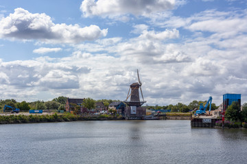 Obraz premium Windmill farm river landscape. Windmill farm scene. Village windmill farm river. Windmill farm river view