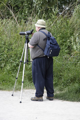 bird watcher with his scope set on a tripod