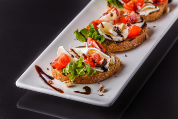 Bruschetta with tomatoes, lettuce, camambert, balsamic vinegar