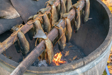 Traditional Scottish smoked fish cooking in wooden barrel. Ancient way of smoked meat. 