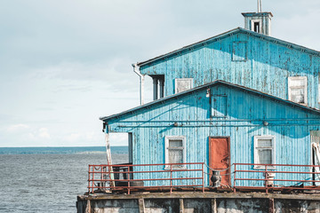 Blue old wooden house on the river. Tourism concept