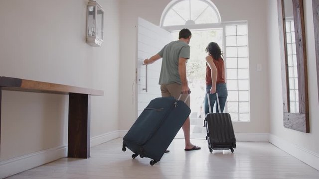 Family With Luggage Opening Front Door And Leaving For Vacation