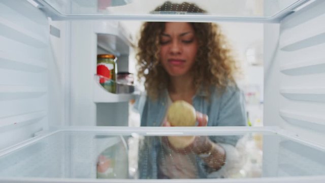 Disappointed Woman Looking Inside Refrigerator Empty Except For Potato On Shelf