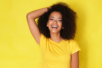 Beautiful smile from young happy model isolated on yellow background.