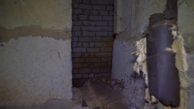 man runs through an old abandoned building, basement with lantern.