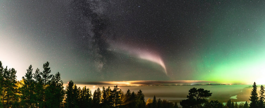 Panoramic view of Northern Lights and atmospheric phenomenon 'STEVE' meets Milky Way. Steve appears as a purple and green light ribbon in the sky at an altitude of 450 km. Northern Sweden Scandinavia © Alexandre Patchine