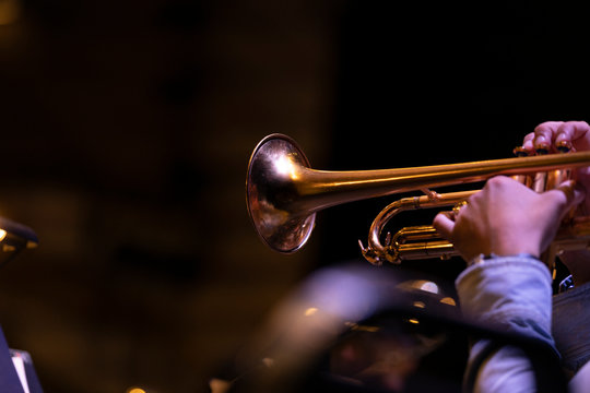 A trumpet player playing on a gold plated matte lacquered trumpet during a performance