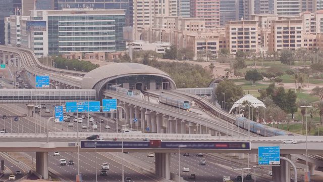 Dubai Golf Course with a cityscape of Gereens and tecom districts at the background aerial view. Traffic on sheikh zayed road with metro station