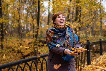 Fat girl on the bridge rejoices around maple leaves and autumn fly