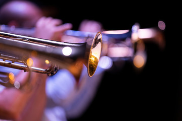 One lacquered trumpet in focus out a big band trumpet section © Janisphoto