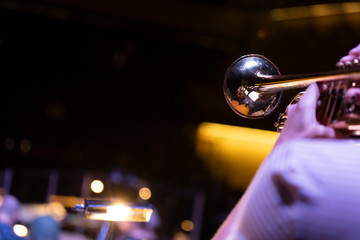 A trumpet player playing on a gold plated matte lacquered trumpet during a performance