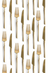 Golden cutlery view from above on a white background. Top view. Knife and fork for a festive table for a wedding, birthday or party.