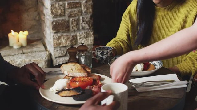 Close Up Of Waitress Working In Traditional English Pub Serving Breakfast To Guests