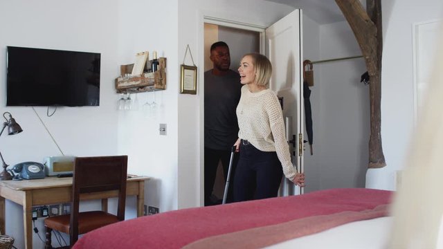 Couple Spending Romantic Weekend Away Opening Door Of Hotel Room And Hugging