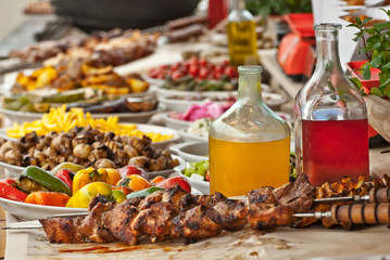 Lots of variety of food on the table. Meat, vegetables and drinks at the city fair.