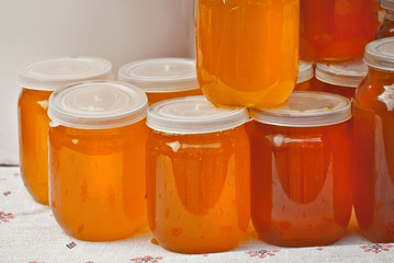 Lots of assorted honey on the table. Jars of sweets are sold at the fair.