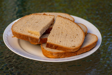 Slices of simple wheat bread on white plate, ready to eat, food and drink