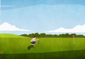 Male golfer preparing tee shot on sunny golf course