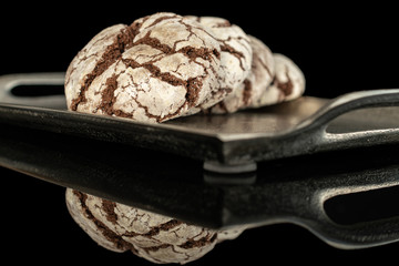 Group of three whole baked chocolate brownie cookie on tray isolated on black glass