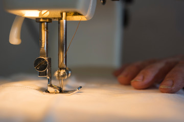 Needle on sewing machine while sewing clothes.