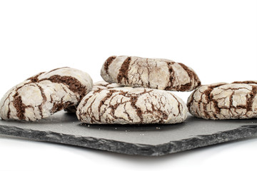 Group of four whole baked chocolate brownie cookie on grey stone isolated on white background