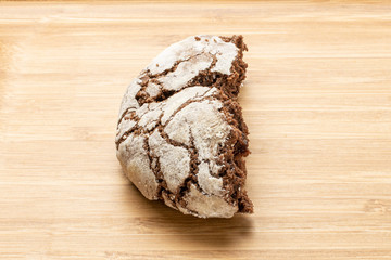 One half of baked chocolate brownie cookie on natural wood