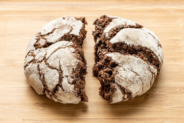 Group of two halves of baked chocolate brownie cookie one cracked on natural wood