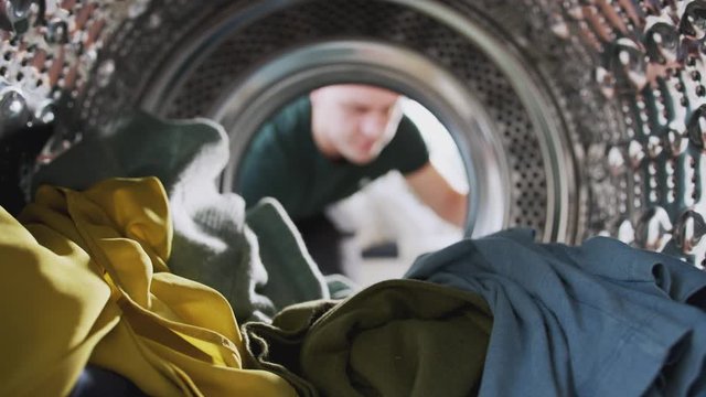 View Looking Out From Inside Washing Machine As Man Takes Out Laundry