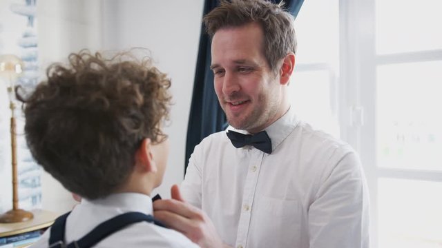 Father And Son Wearing Matching Outfits Getting Ready For Wedding At Home