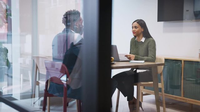 Businesswoman Interviewing Male Job Candidate In Meeting Room