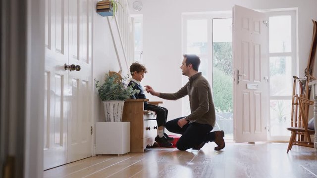Single Father At Home Getting Son Wearing Uniform Ready For First Day Of School