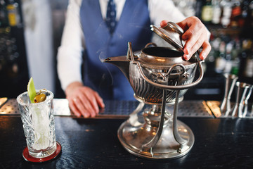 Cocktail at bar. Expert Bartender is making alcoholic cocktail.