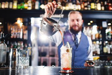 Cocktail at bar. Expert Bartender is making alcoholic cocktail.