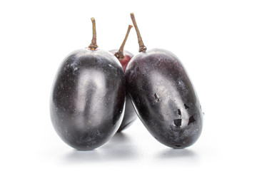 Group of three whole fresh black grape isolated on white background