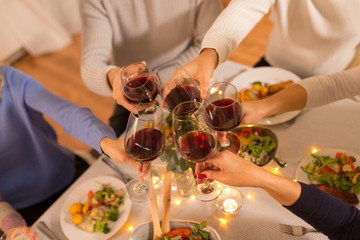 celebration, holidays and people concept - happy family having dinner party, drinking red wine and toasting at home