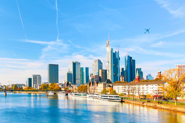 Fototapeta premium Skyline cityscape of Frankfurt, Germany during sunny day with a plane. Frankfurt am Main is a financial capital of Europe.