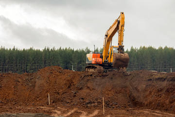 Obraz premium Work of special equipment at a construction site. Crawler excavator performs earthwork.